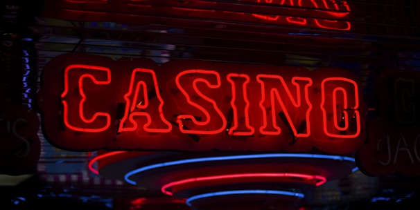 Neon lights display the word 'CASINO' in bright red, standing out against a dark background. The vibrant glow reflects a lively and bustling atmosphere.
